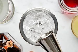 vodka and cointreau added to a cocktail to make a cosmopolitan cocktail