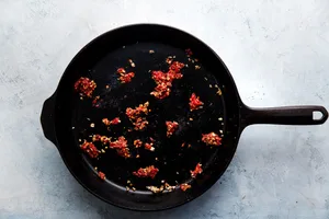 tomato paste and garlic in a cast iron skillet