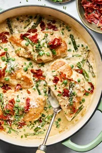 homemade Creamy Chicken Skillet with Asparagus Peas topped with prosciutto, chives, Parmesan & pepper