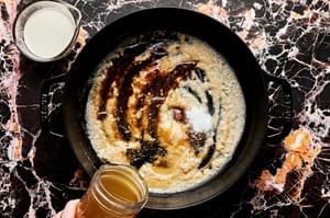 cream sauce with butter, flour, stock, spices, Worcestershire and heavy cream being cooked in a skillet