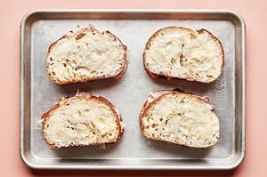 sandwiches made with buttered bread with ham, Gruyère and topped with another piece of buttered bread on a baking sheet