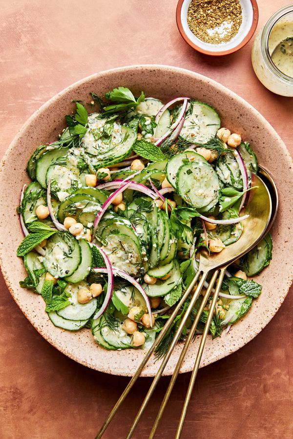 cucumber salad made with chickpeas, red onion, parsley, mint and dill with homemade salad dressing in a serving bowl