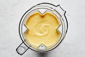 dairy free cheese sauce in a blender made with stock, vegan cheese & vegan butter, nutritional yeast, spices, boiled potatoes