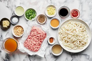 udon noodles, ground pork, peanut butter, chicken stock, soy sauce and spices in prep bowl to make dan dan noodles