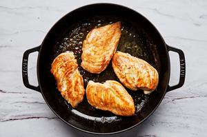 chicken seasoned with salt being cooked in butter in a skillet
