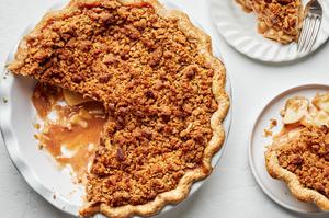 a homemade dutch apple pie being sliced and served on plates