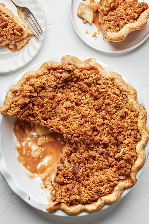 a homemade Dutch apple pie being sliced and served on plates