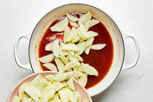 apples being added a skillet with butter, flour, sugar, brown sugar, lemon juice, water, cinnamon and nutmeg