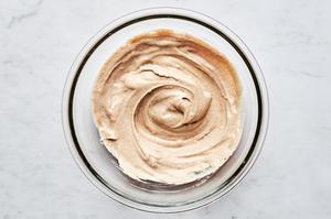 Whipped cream, mascarpone, maple syrup, cinnamon, and vanilla mixed together in a bowl for a creamy tiramisu filling.