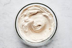 Whipped cream, mascarpone, maple syrup, cinnamon, and vanilla mixed together in a bowl for a creamy tiramisu filling.