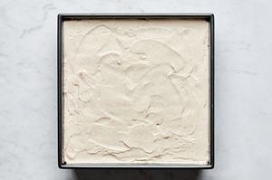 tiramisu being layered in a pan with layers of coffee soaked lady fingers and whipped spiced mascarpone
