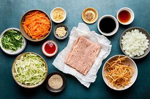 ground turkey, carrots, cabbage, onion, garlic, ginger, soy sauce, sriracha, wonton strips & sesame seeds in bowls