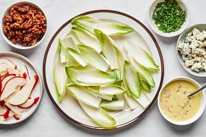 endives, pear, Roquefort, chives, candied walnuts and pear vinaigrette in bowls ready to assemble a salad