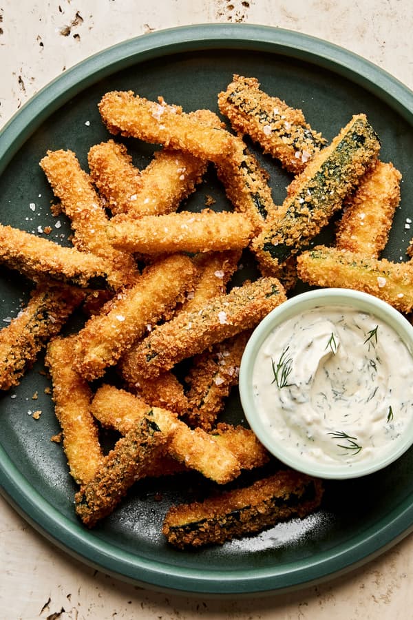 Golden-brown, extra crispy fried zucchini sticks sprinkled with flaky salt served with a side of creamy dill dip.