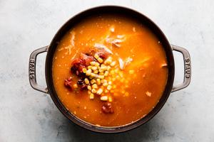 corn, chicken stock, shredded rotisserie chicken, canned tomatoes and enchilada sauce in a soup pot.