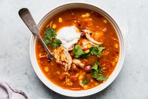 5 ingredient chicken tortilla soup in a bowl with cilantro and sour cream
