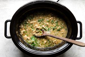 Green Chicken Chili Soup in a slow cooker made with stock, onions, green bell peppers, salsa, garlic & beans