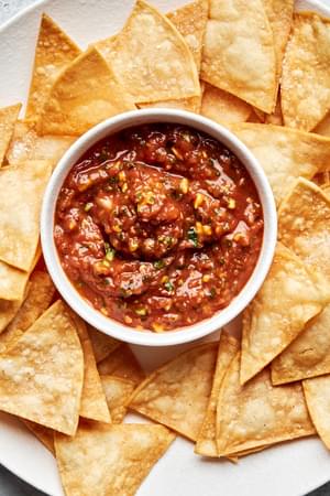 a bowl of homemade salsa surrounded by tortilla chips