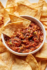 a bowl of homemade salsa surrounded by tortilla chips