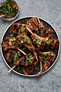 Garam Masala Grilled Lamb Chops on a serving plater next to a small bowl filled with Mint Chutney