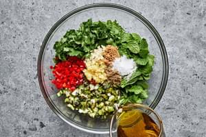 chopped green onions, mint, cilantro, garlic, ginger, garam masala, chiles, brown sugar, salt, and vinegar in a glass bowl