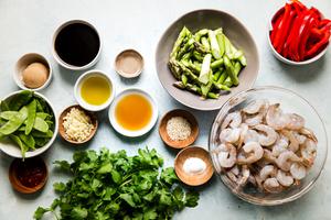 Ingredients laid out for garlic shrimp stir fry red bell peppers, asparagus, cilantro