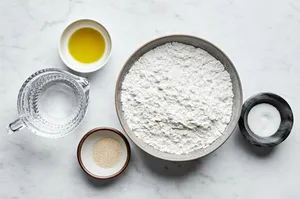instant dry yeast, warm water, olive oil, gluten free flour and salt in bowls to m ake gluten free pizza dough