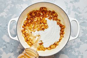 stock, coconut milk, sugar, and lemon juice being added to a pot with onion and spices