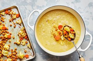roasted chickpeas and veggies being added to a pot of stock, coconut milk, sugar, lemon juice and spices.