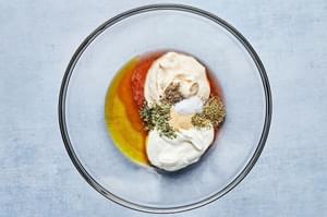 olive oil, mayonnaise, Greek yogurt, vinegar, garlic powder, oregano, basil, sea salt and pepper in a glass bowl