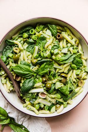 green goddess pasta salad in a serving bowl with a wooden serving spoon