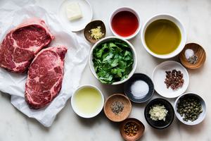 ingredients laid out for grilled ribeye steak with Italian salsa verde. olive oil, garlic, capers, anchovies, salt, parsley