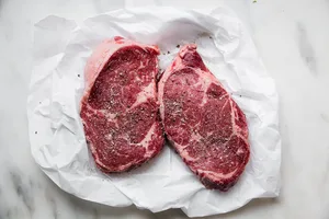 2 rib eye steaks on parchment paper