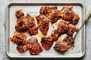 red curry marinated chicken thighs on a baking sheet