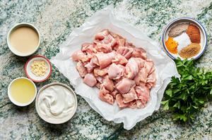 chicken, Greek yogurt, spices, tahini, lemon juice and garlic in prep bowls to make grilled chicken shawarma kebab