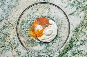 yogurt, cumin, cardamom, turmeric, cinnamon, and salt in a glass bowl to make shawarma marinade