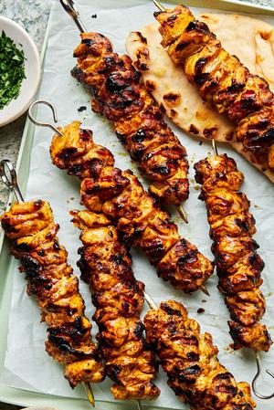 grilled chicken shawarma kebab on a serving plate being served with pita bread