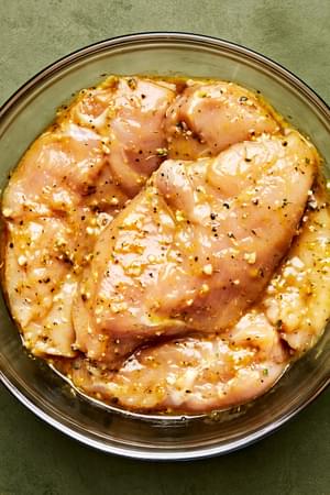 chicken being marinated in olive oil, garlic, thyme, basil, salt, pepper, lemon zest, mustard, Worcestershire & brown sugar