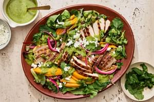 grilled curry chicken salad topped with mango slices, pickled onion, goat cheese, cilantro, mint and herb vinaigrette