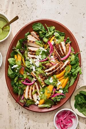 grilled curry chicken salad topped with mango slices, pickled onion, goat cheese, cilantro, mint and herb vinaigrette