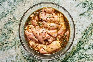 chicken marinating in honey, mustard, olive oil, lemon juice, cilantro, garlic, curry powder, salt, pepper, and red pepper