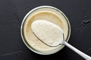 homemade Caesar dressing in a jar with a spoon