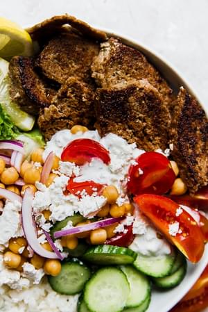 gyro bowl with cucumbers, lemon rice, feta, red onion, tomatoes, lettuce and gyro meat