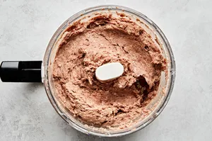 raw ground beef and lamb being mixed in a food processor until a paste forms