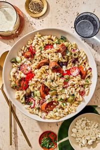 gyro pasta salad with sausage, olives, parsley, red onion, feta, tomatoes & cucumbers  in a Greek yogurt dressing