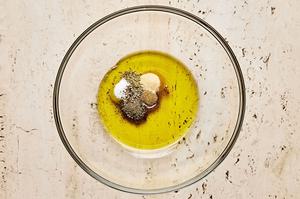 thyme, granulated garlic, cumin, oregano, pepper, salt, and olive oil being combined in a bowl