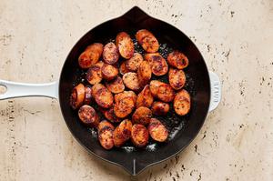 sliced Italian sausage tossed with thyme, granulated garlic, cumin, oregano, pepper, salt, and olive oil cooked in a skillet