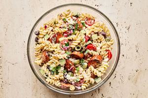 gyro pasta salad with sausage, olives, parsley, red onion, feta cheese, tomatoes & cucumbers in a Greek yogurt dressing