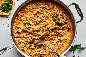 a pan of homemade hamburger helper made with macaroni, ground beef, milk, butter, beef stock, cheese and spices