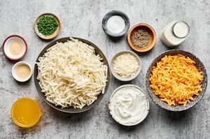 shredded potatoes, cheese, sour cream, heavy cream, butter, garlic powder, onion powder, salt, and pepper in prep bowls